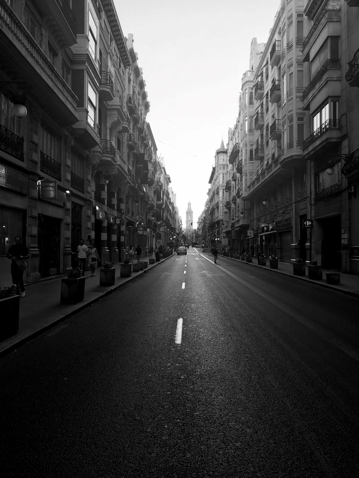 Schwarz-weiß Bild, lange Straße umgeben von Gebäuden